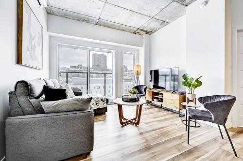 a living room with a couch and a table at Panorama Penthouse- piscine, gym et vue sur Québec in Quebec City