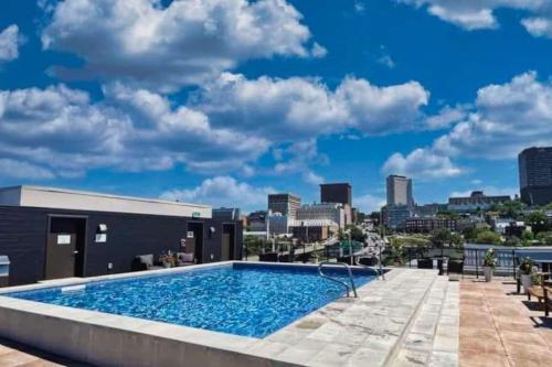 a swimming pool on top of a building with a city skyline at Panorama Penthouse- piscine, gym et vue sur Québec in Quebec City