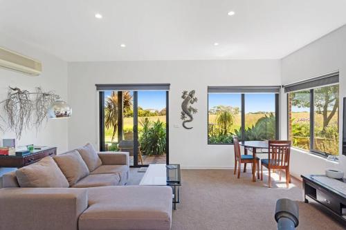 a living room with a couch and a table at Coastal meets Country at this Ventnor Beach Escape in Ventnor