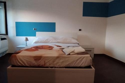 Schlafzimmer mit einem großen Bett mit blauem Kopfteil in der Unterkunft Casa la Gardenia in SantʼOreste