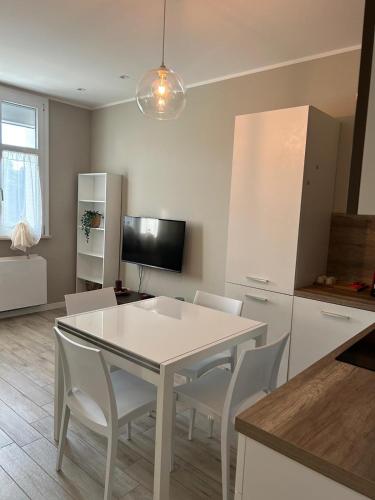 a kitchen with a white table and white chairs at Residenza Il Principe Bilocale 3, Centro in Parma