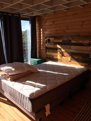 a large bed in a room with a window at PEZ HOUSE in Pichilemu