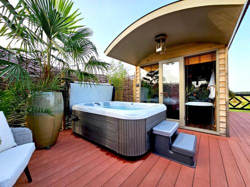 a hot tub sitting on top of a wooden deck at Lavish Country Retreat 30mins Taxi Ride From West London in Chessington
