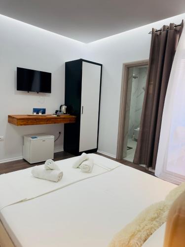 a bedroom with a bed with two towels on it at Villa Merkuri in Himare