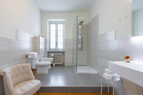 een witte badkamer met een toilet en een douche bij Saint Paul Luxury Holiday Home by Alterego in San Paolo Solbrito