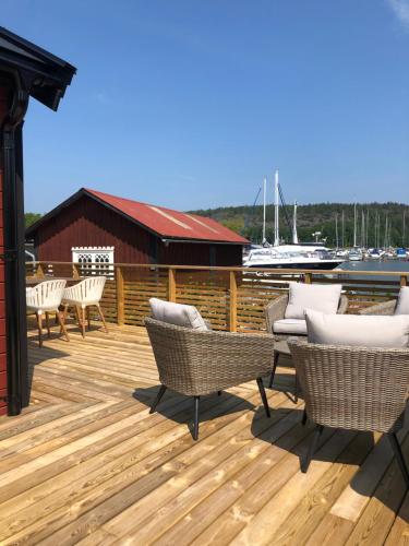 una terraza con sillas y mesas y un puerto deportivo en Lyxiga stugor med sjöutsikt, en Söderköping