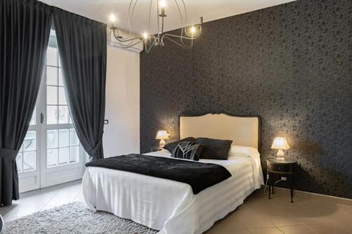 een slaapkamer met een groot bed met een zwarte muur bij Saint Paul Luxury Holiday Home by Alterego in San Paolo Solbrito