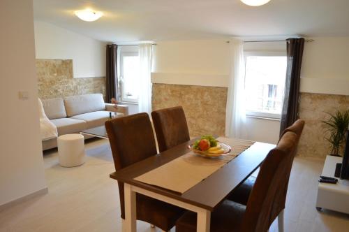 sala de estar con mesa, sillas y sofá en Central Apartment Adria, en Rovinj