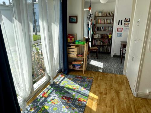 um quarto com um tapete no chão ao lado de uma janela em Agréable maison à 500 m de la plage ! em Saint-Quay-Portrieux