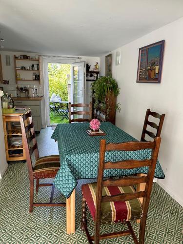 une salle à manger avec une table et des chaises et une cuisine dans l'établissement Agréable maison à 500 m de la plage !, à Saint-Quay-Portrieux