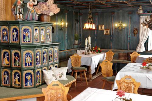 a dining room with two tables and a large cabinet with paintings at Käfernberg - Weinhotel in Alzenau in Unterfranken