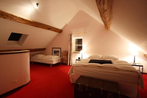 une chambre avec un grand lit dans un grenier dans l'établissement La Maison de Violette, à Baigneux-les-Juifs