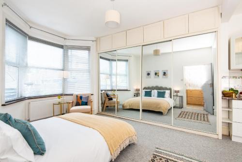 a bedroom with two beds and a large mirror at Ground Floor En-Suite Room with a Private Kitchen and Parking in a 5-Bedroom House at Hanwell in Hanwell