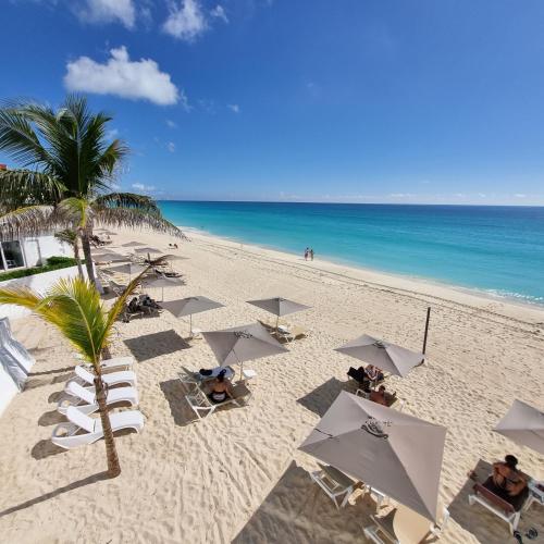 a beach with chairs and umbrellas and the ocean at Estudio 1A sobre hermosa playa, excelente opción in Cancún