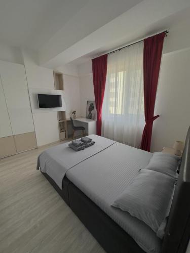 een slaapkamer met een groot bed met rode gordijnen bij Divine Comfort Apartments Palas Mall in Iaşi