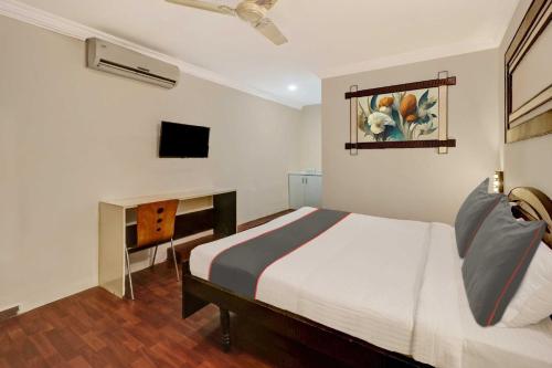 a bedroom with a bed and a desk and a television at Sabharwal Residency Near Lalbagh Botanical Garden in Bangalore