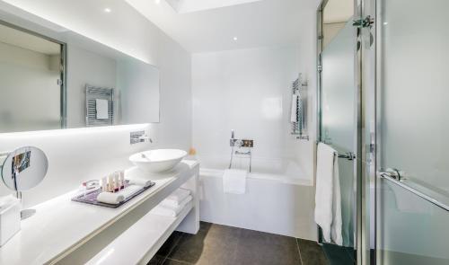 a white bathroom with a sink and a shower at Monte-Carlo Bay Hotel & Resort in Monte Carlo