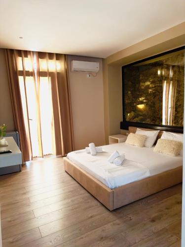 a bedroom with a large bed and a large painting on the wall at Villa Merkuri in Himare