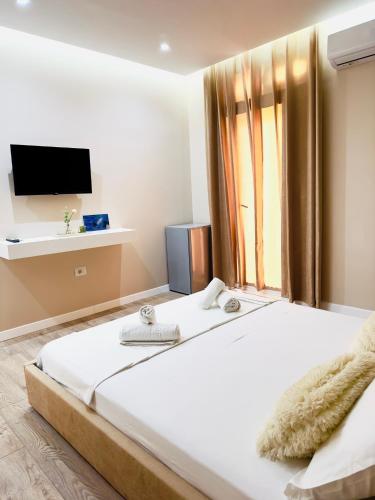 a bedroom with a large bed and a tv at Villa Merkuri in Himare