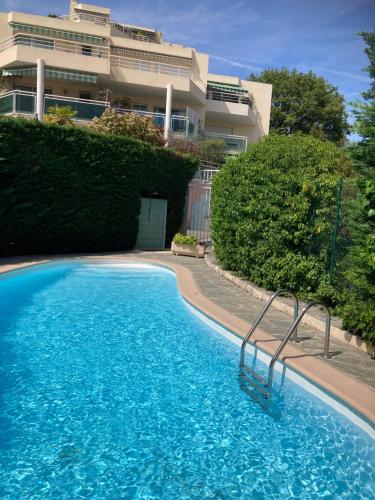 een groot blauw zwembad voor een gebouw bij Superbe Studio parking piscine in Nice