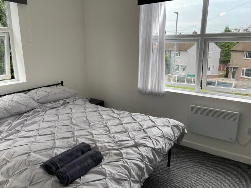a bedroom with a bed with two towels on it at Swinefleet Maisonettes. Airy, Modern & Chic! in Goole