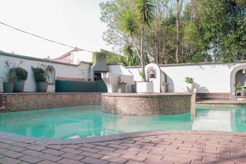 a swimming pool with turquoise water in front of a house at 3 Liebeloft Guest House in Edenvale