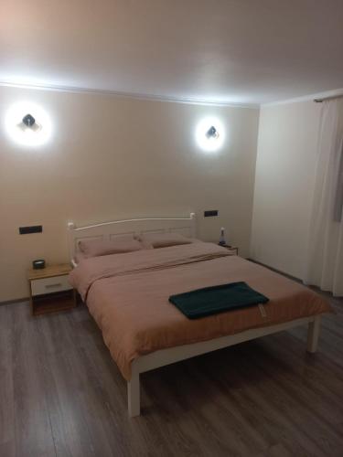 a bedroom with a bed with two lights on the wall at Casa Edy in Vişeu de Sus