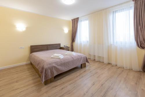 a bedroom with a bed with two towels on it at Villa Class in Sînmartin
