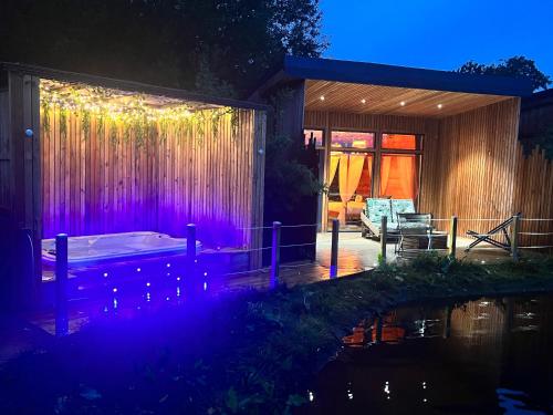 Cette maison dispose d'une terrasse avec des lumières violettes. dans l'établissement JUNGLE - Le Domaine Wambrechies, à Wambrechies