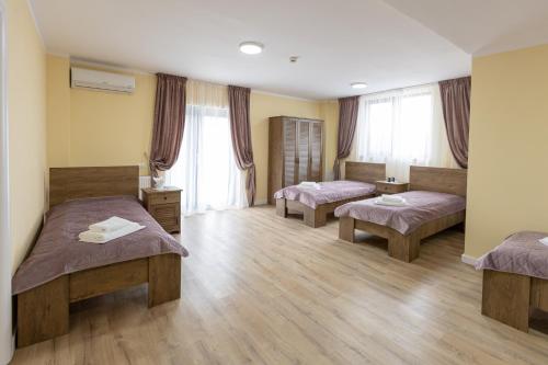 Habitación hospitalaria con 3 camas y ventanas en Villa Class, en Sînmartin