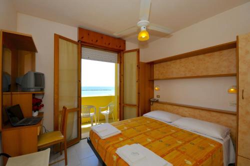 a bedroom with a bed and a television and a window at Hotel Real in Cesenatico