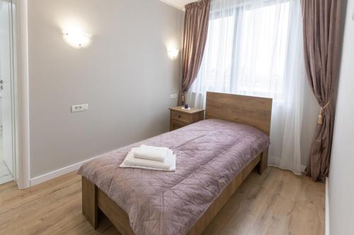 a bedroom with a bed with two towels on it at Villa Class in Sînmartin