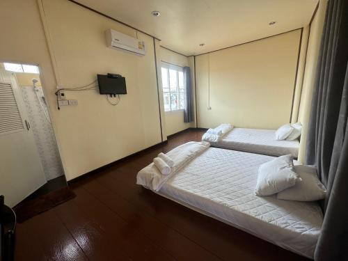 a hotel room with two beds and a tv at โฮมสเตย์ภูมิใจ เชียงคาน ซอย 17 in Loei