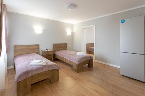 a room with two beds and a refrigerator at Villa Class in Sînmartin