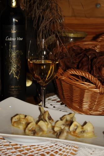 a plate of dumplings and a glass of wine at Guest House and Museum Firšt in Solčava