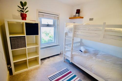 ParkstoneにあるModern 3 bed w/ garden, nr beachのベッドルーム1室(二段ベッド2台、窓付)が備わります。