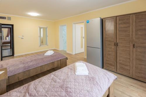a bedroom with two beds and a refrigerator at Villa Class in Sînmartin