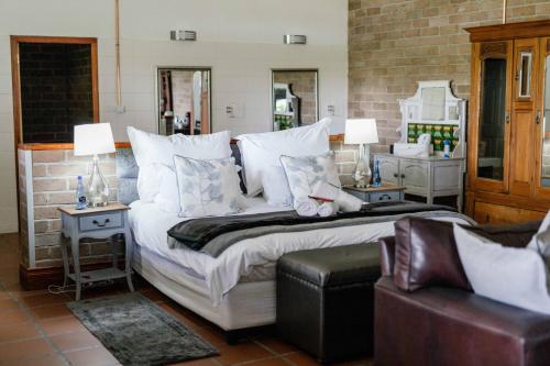 a bedroom with a large bed with white pillows at Upington African Vineyard Boutique Hotel & SPA in Kanoneiland