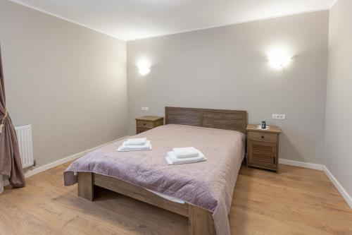 a bedroom with a bed with two towels on it at Villa Class in Sînmartin