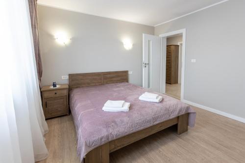 a bedroom with a bed with two towels on it at Villa Class in Sînmartin