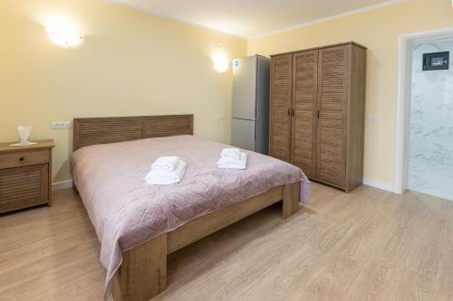 a bedroom with a bed with two towels on it at Villa Class in Sînmartin