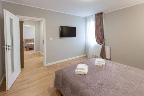 a bedroom with a bed with two towels on it at Villa Class in Sînmartin