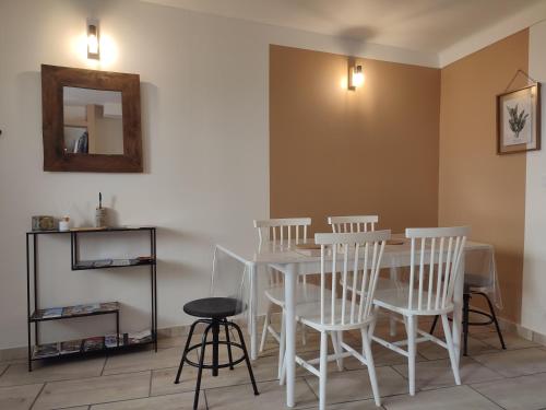 une salle à manger avec une table blanche et des chaises blanches dans l'établissement Maison numéro 5, à Châteauneuf-du-Pape