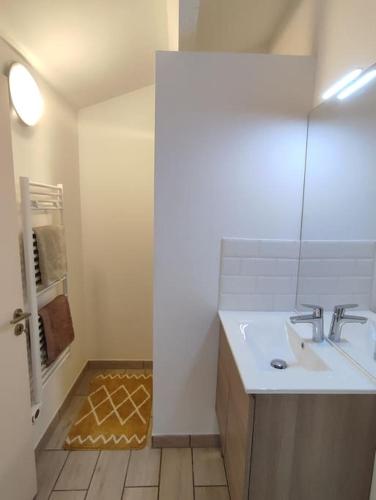 une salle de bain blanche avec un lavabo et une douche dans l'établissement Maison numéro 5, à Châteauneuf-du-Pape