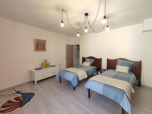 une chambre avec deux lits et un lustre dans l'établissement Maison numéro 5, à Châteauneuf-du-Pape