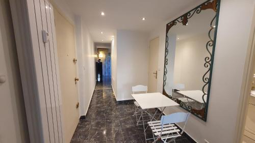 un miroir ainsi qu'une table et des chaises dans le couloir dans l'établissement New Centre ville 3P clim, à Antibes