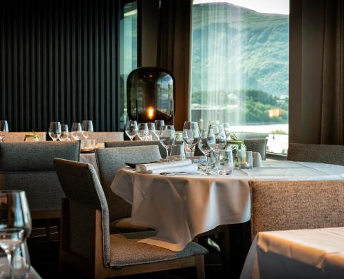 a dining room with tables and chairs with wine glasses at Scandic Parken in Ålesund