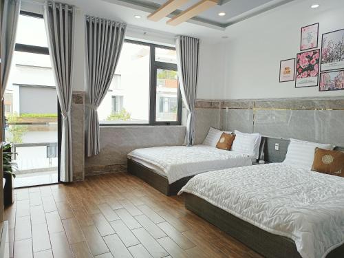 ein Hotelzimmer mit 2 Betten und einem Fenster in der Unterkunft Thiên Lam Homestay in Cần Thơ