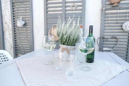a table with wine glasses and a bottle of wine at Casa Palfy in Oslip
