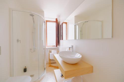 a white bathroom with a sink and a shower at Casa Dalia, colazione inclusa e vista panoramica in Assisi
